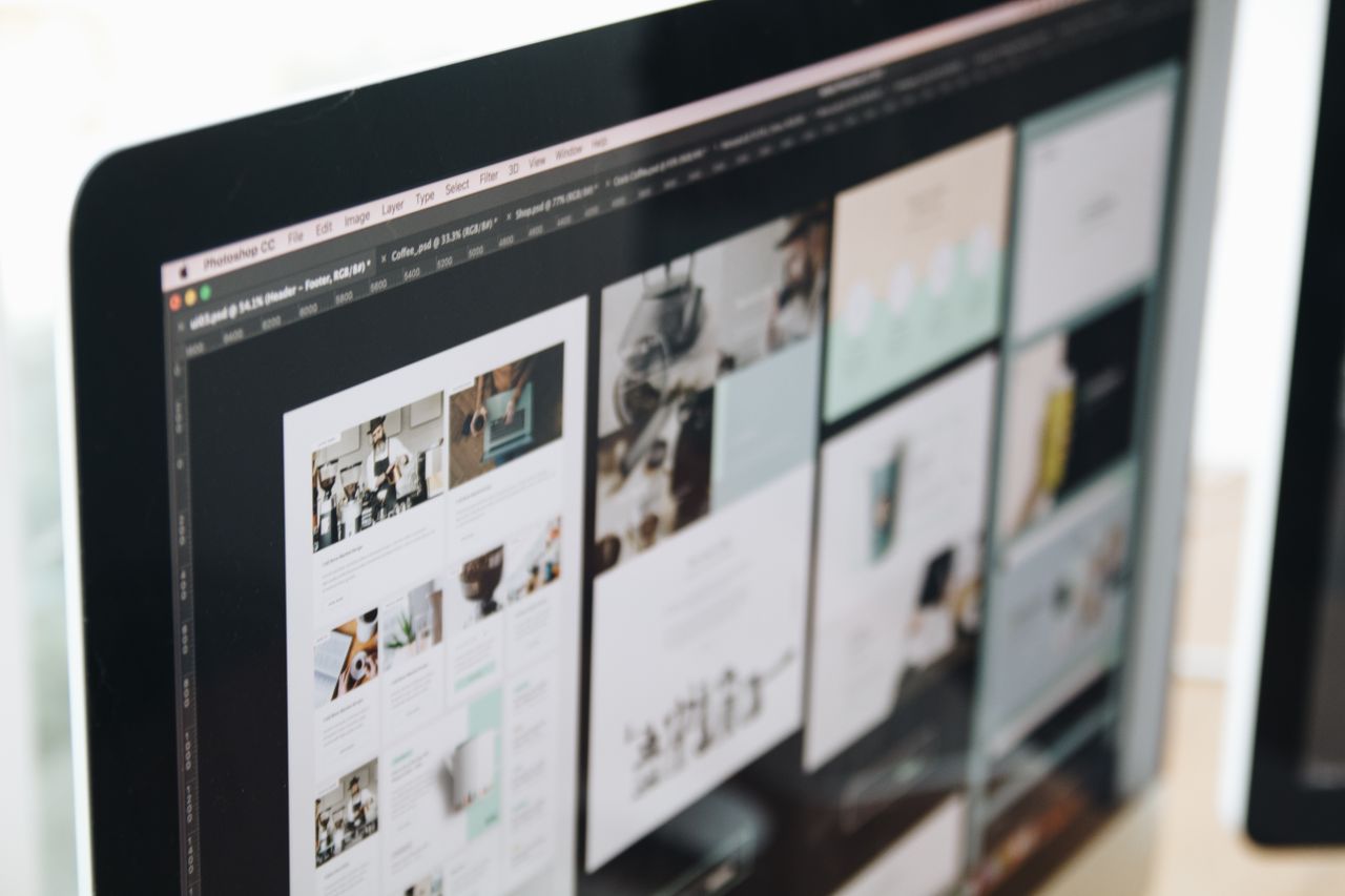 Un écran d’ordinateur moderne affichant un travail de conception web, mettant en valeur des visuels créatifs dans un espace de travail.